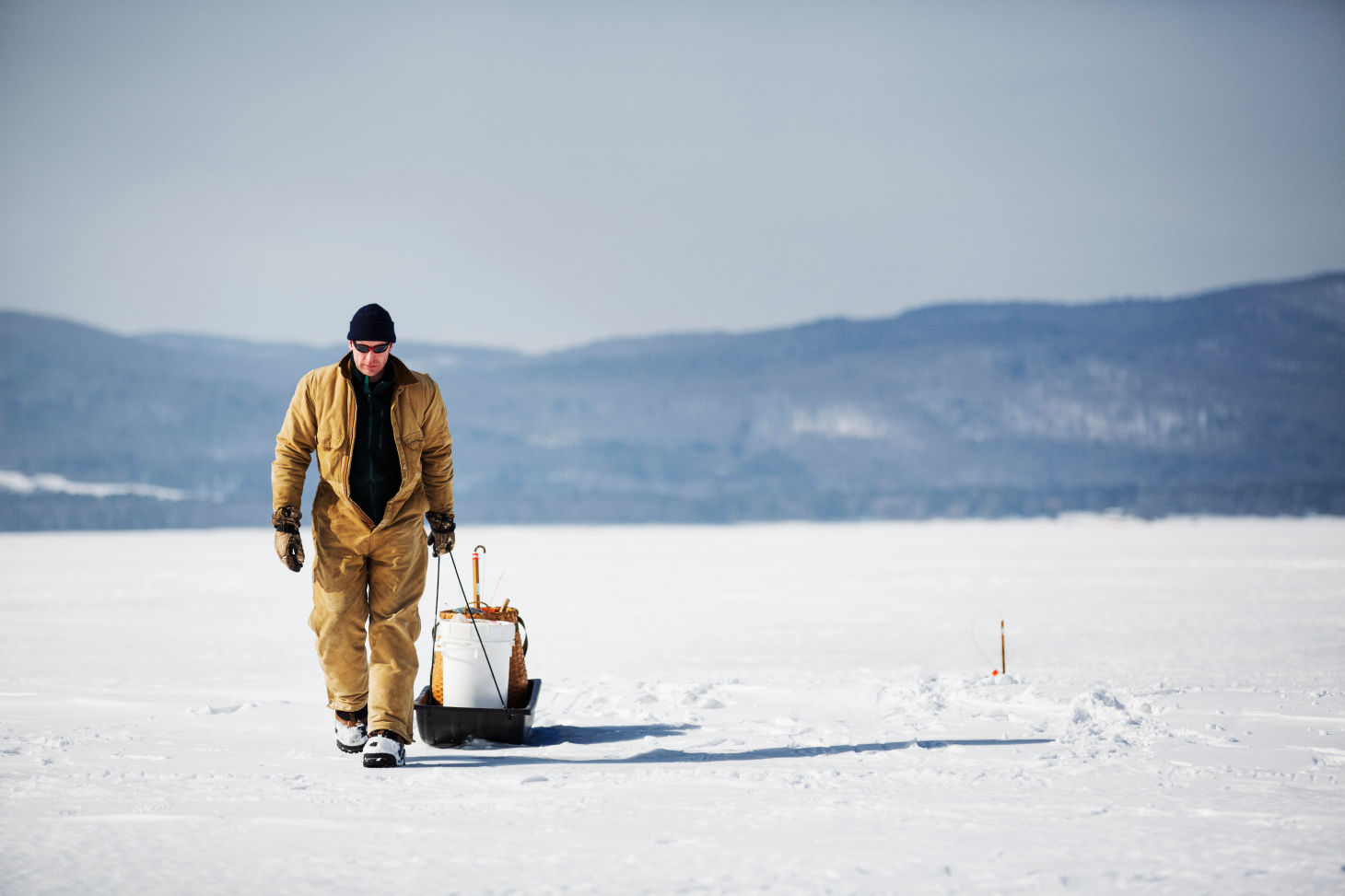 Homme sur la neige qui revient de la pêche