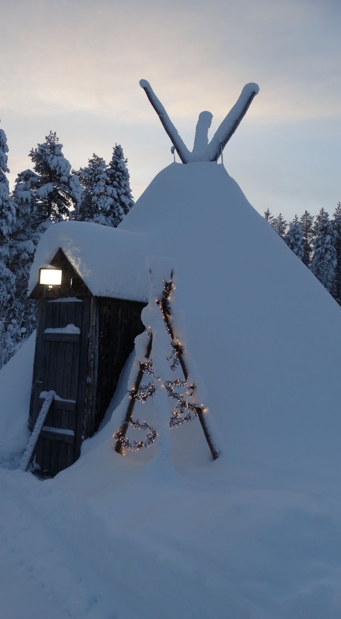Tipi en bois recouvert de neige dans le jardin
