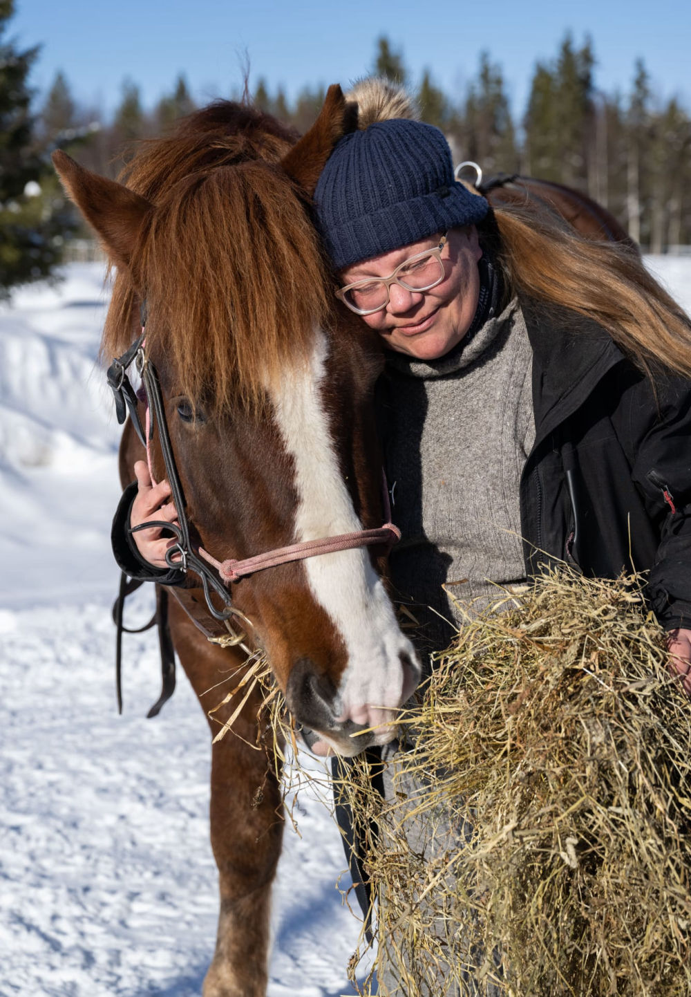 Mia, organisatrice de ballades à cheval, pose ici avec un cheval.