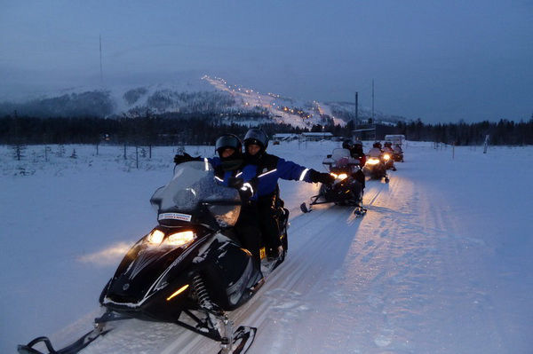Motoneige en groupe dans la nuit